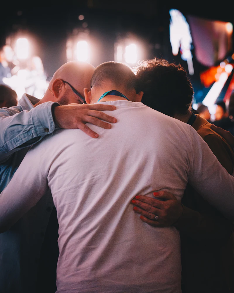 Dois homens se abraçando durante um momento de louvor