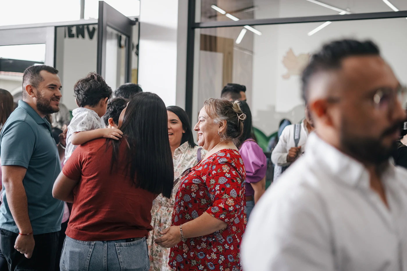 Pessoas conversando e se cumprimentando no saguão da igreja