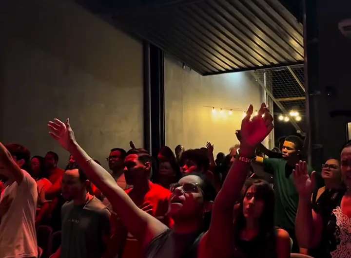 Igreja de pé adorando, com as mãos levantadas