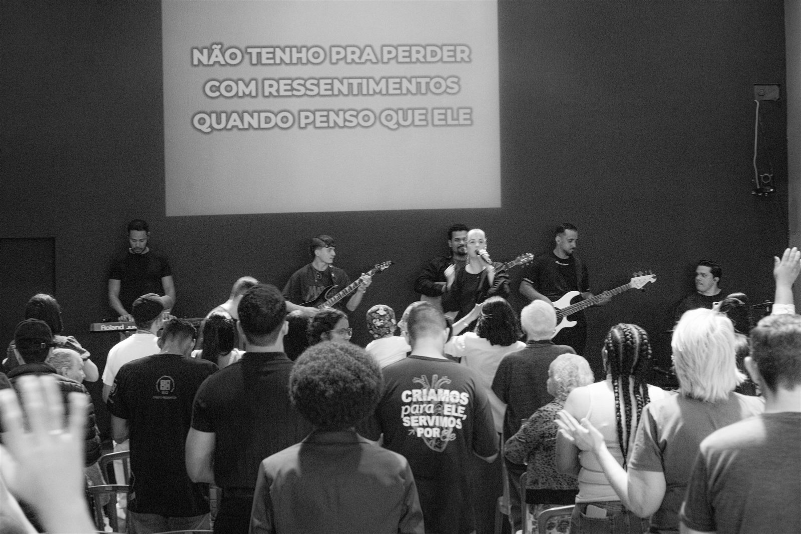 Banda conduzindo o louvor no palco enquanto a igreja canta