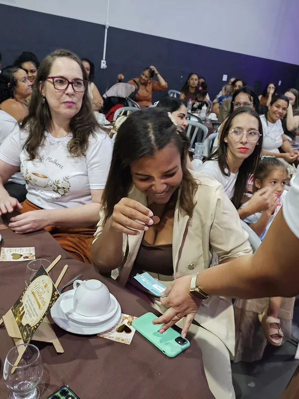 Mulheres conversando e rindo à mesa